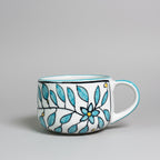 Ceramic mug with blue floral design on a wooden surface
