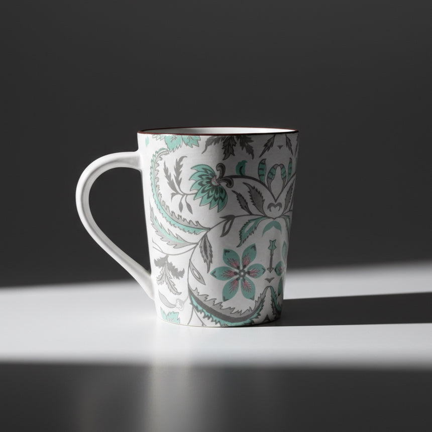 White mug with floral pattern on a wooden surface