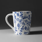 White mug with blue floral pattern on a wooden surface