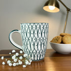 White mug with black geometric pattern on a wooden surface