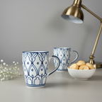 White mug with blue geometric pattern on a wooden surface