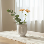 White ceramic cup with a face design on a wooden surface and beige wall background