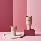Set of four ceramic pots stacked on a wooden surface with a blurred indoor background.