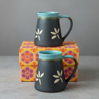 Ceramic mug with floral design on a wooden surface