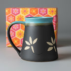 Blue ceramic mug with floral design on a wooden surface